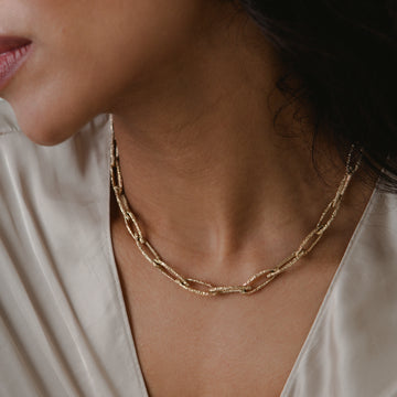 textured chain link necklace made from solid gold worn on a model 