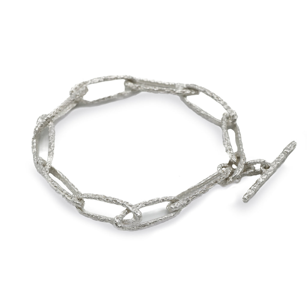 textured silver link bracelet on white background 