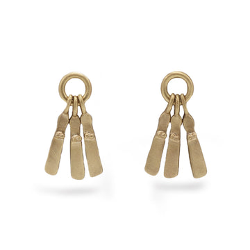 A pair of yellow gold mini Sibyl earrings with a brushed matt finish, hanging from a mini silver hoop. On a white background