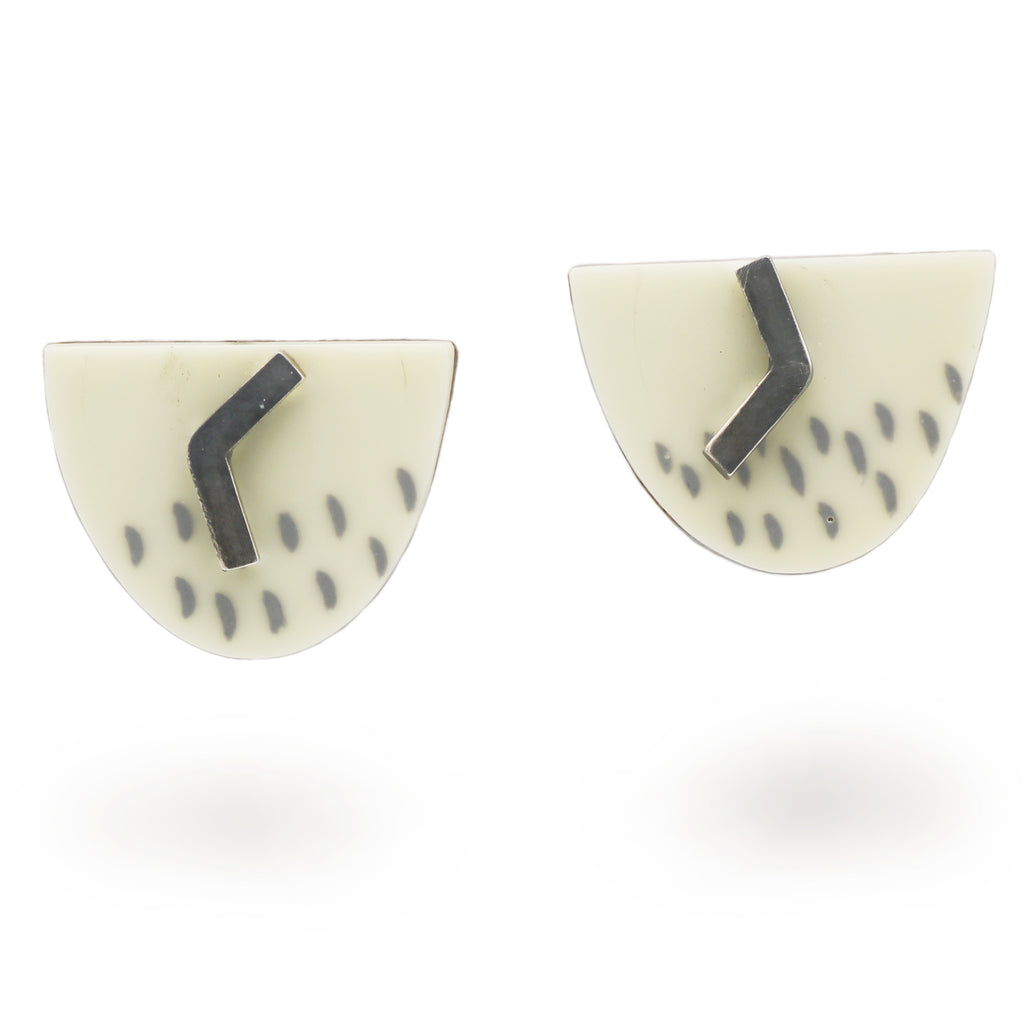 cream stud earrings with oxidised silver details on a white background