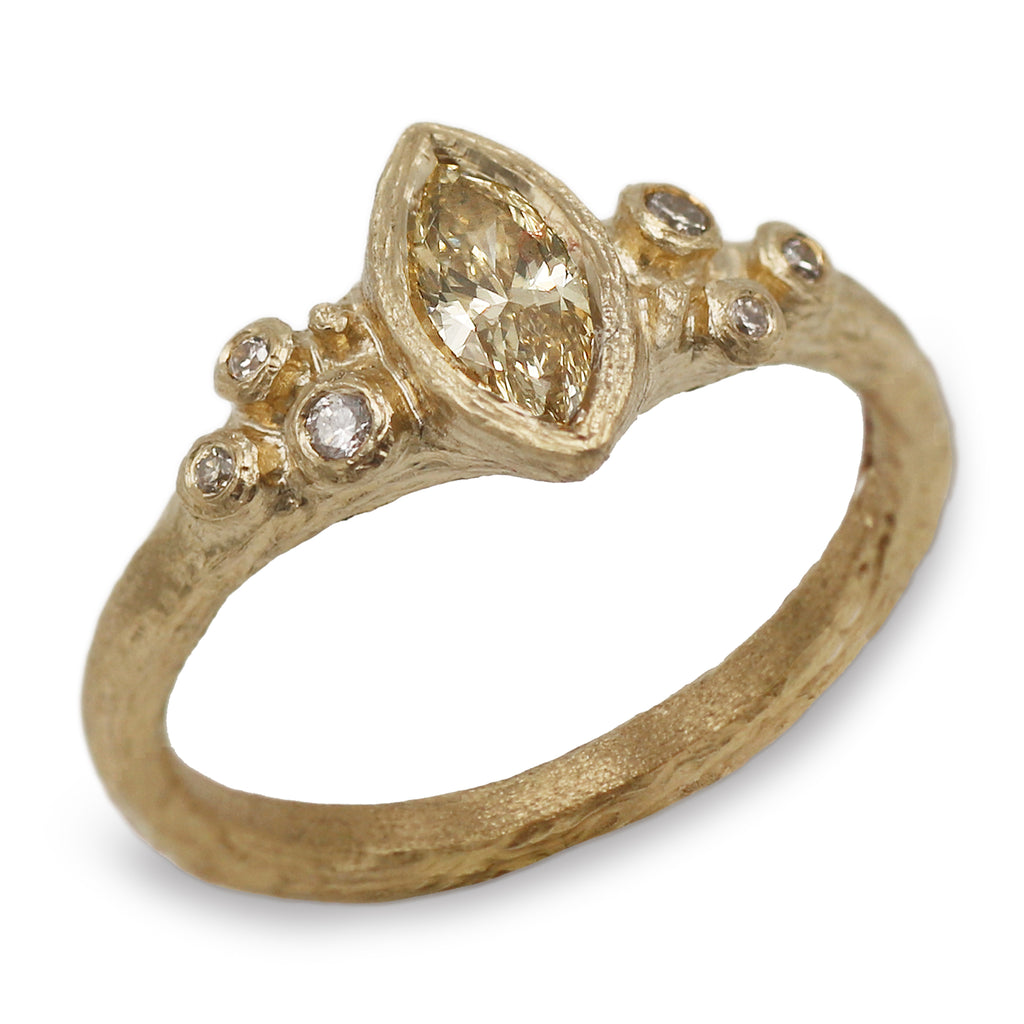 yellow gold marquise diamond ring with textured finish on a white background 