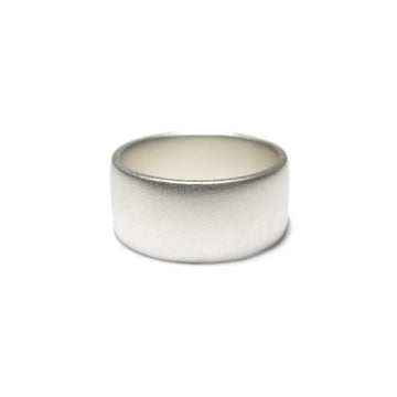 Wide silver ring with matt finish on a white background