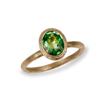 Textured Yellow Gold Ring With a Green Oval Tsavorite Garnet on white background