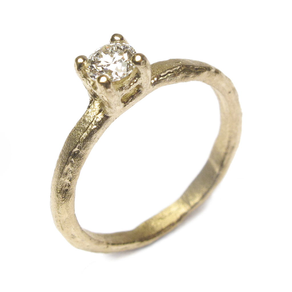 A textured yellow gold ring with a brilliant cut natural brown diamond in a claw setting on an etched Fairtrade 18ct ethical yellow gold band.