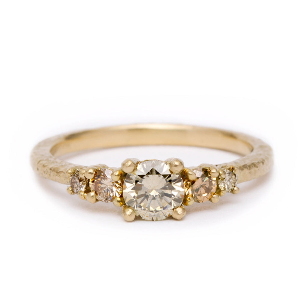 Gold ring with five champagne diamonds on a white background
