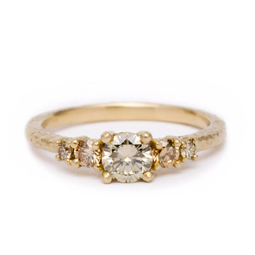 Gold ring with five champagne diamonds on a white background