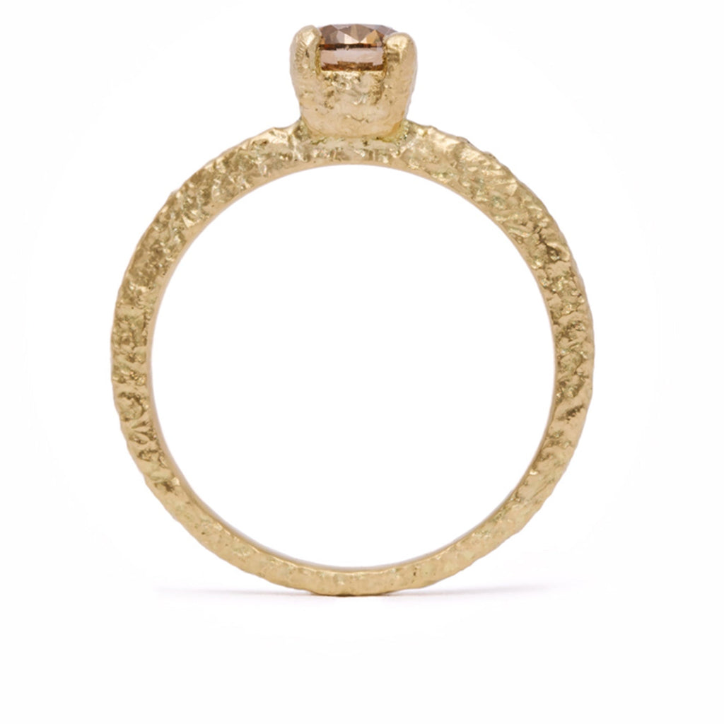 side profile view of Gold ring with a textured band on a white background