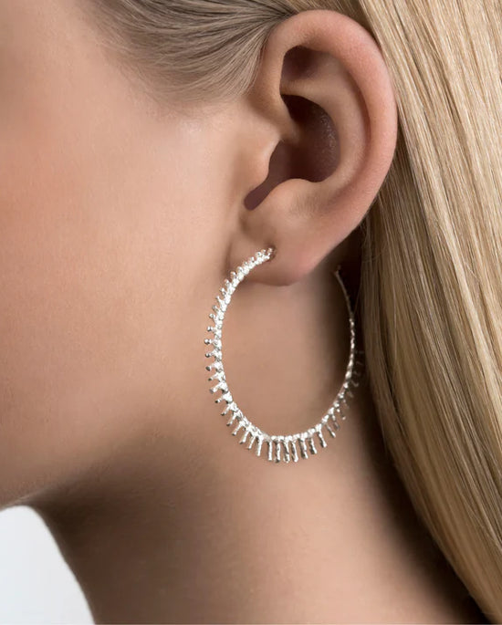 woman with blonde hair wearing large spikey silver hoops in her ear