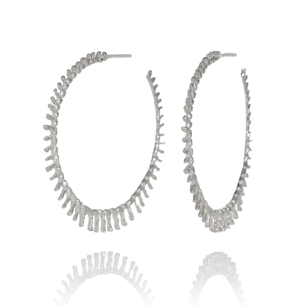 A pair of silver hoop earrings with a spiky design, part of the 'Asterias' collection.