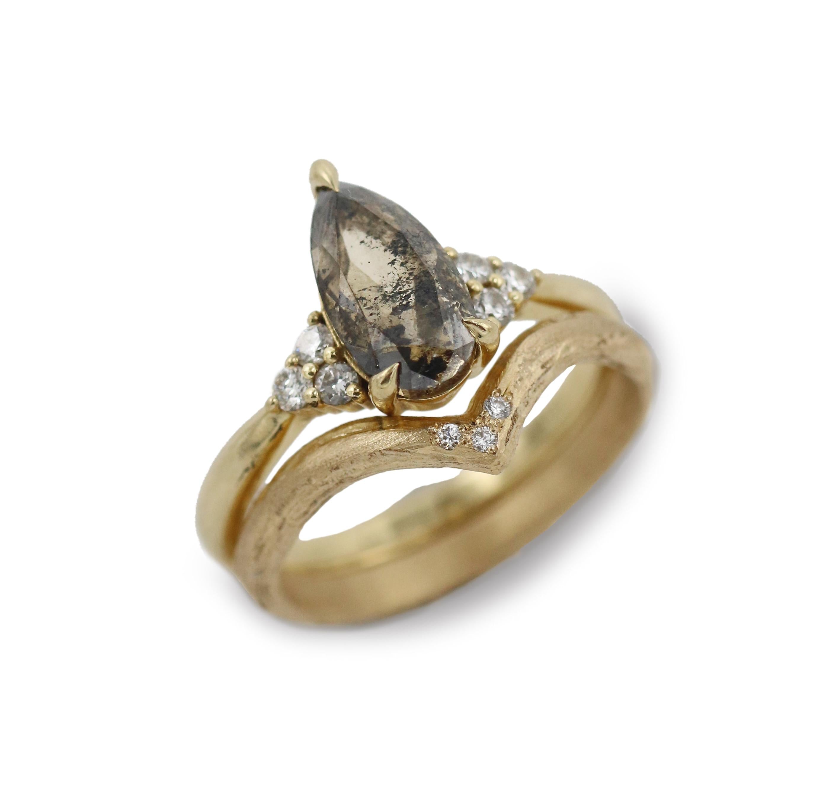 Gold wishbone ring with diamonds and a salt and pepper diamond ring on white background 