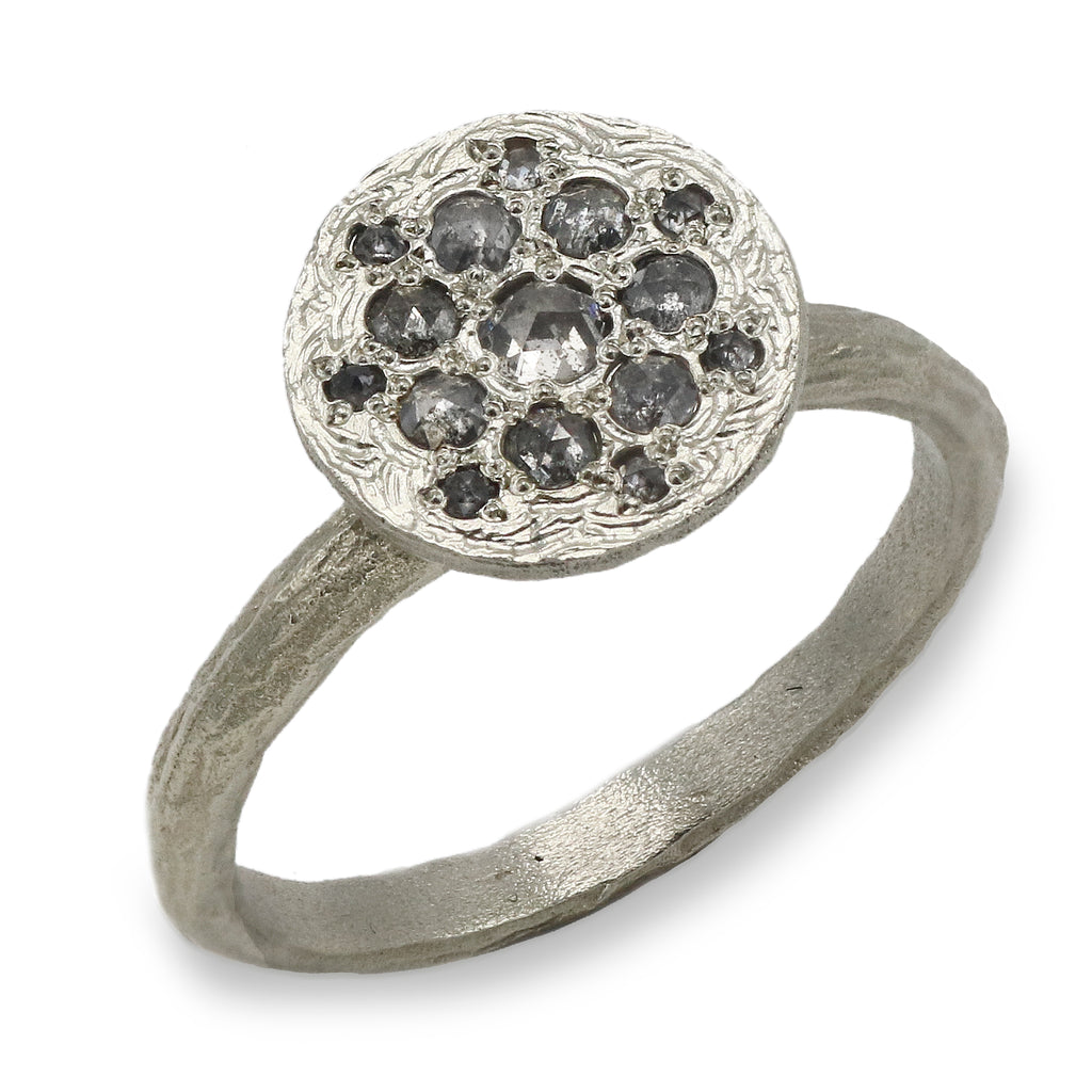 Patterned white gold ring with salt and pepper diamonds on a white background 