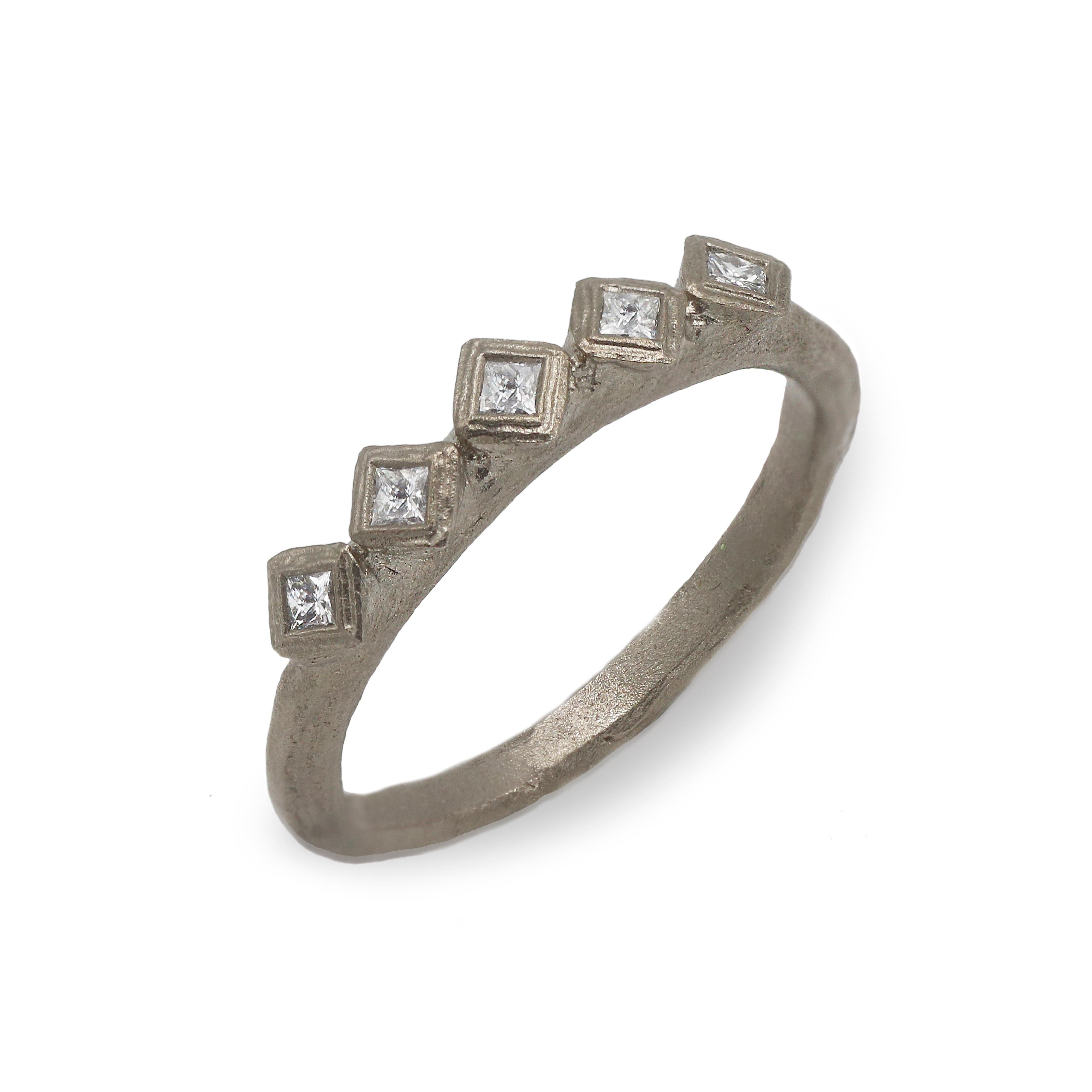 modern white gold eternity ring with princess cut diamonds on a white background 