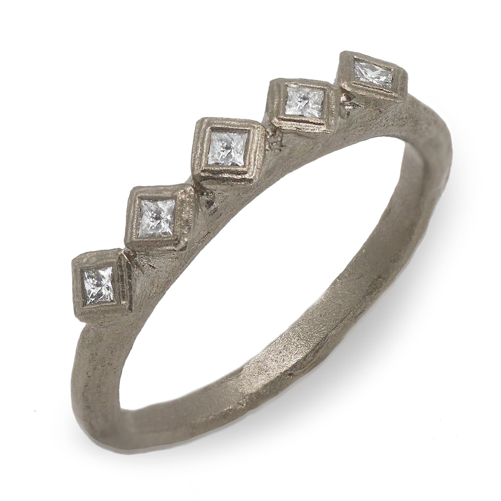 modern white gold eternity ring with princess cut diamonds on a white background 