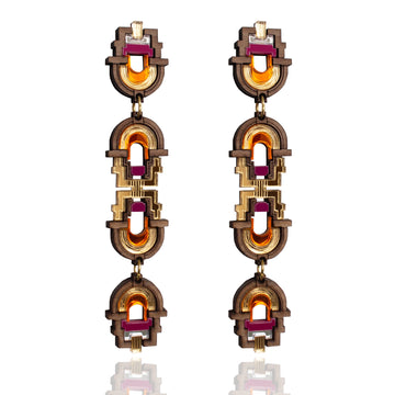 Pair of ornate earrings with gold and red accents on a white background