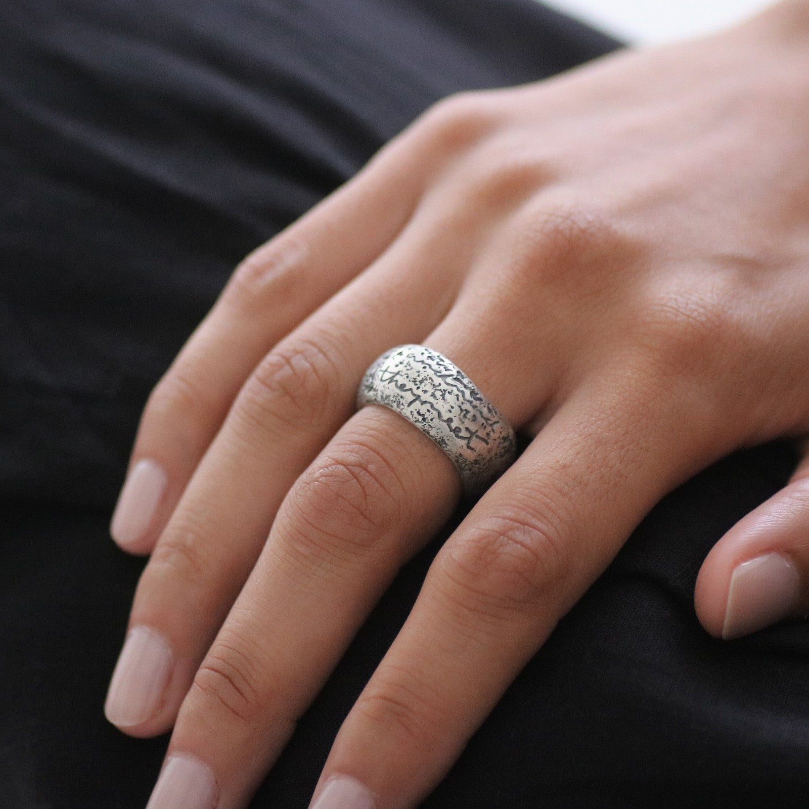 A silver contemporary ring design with etching