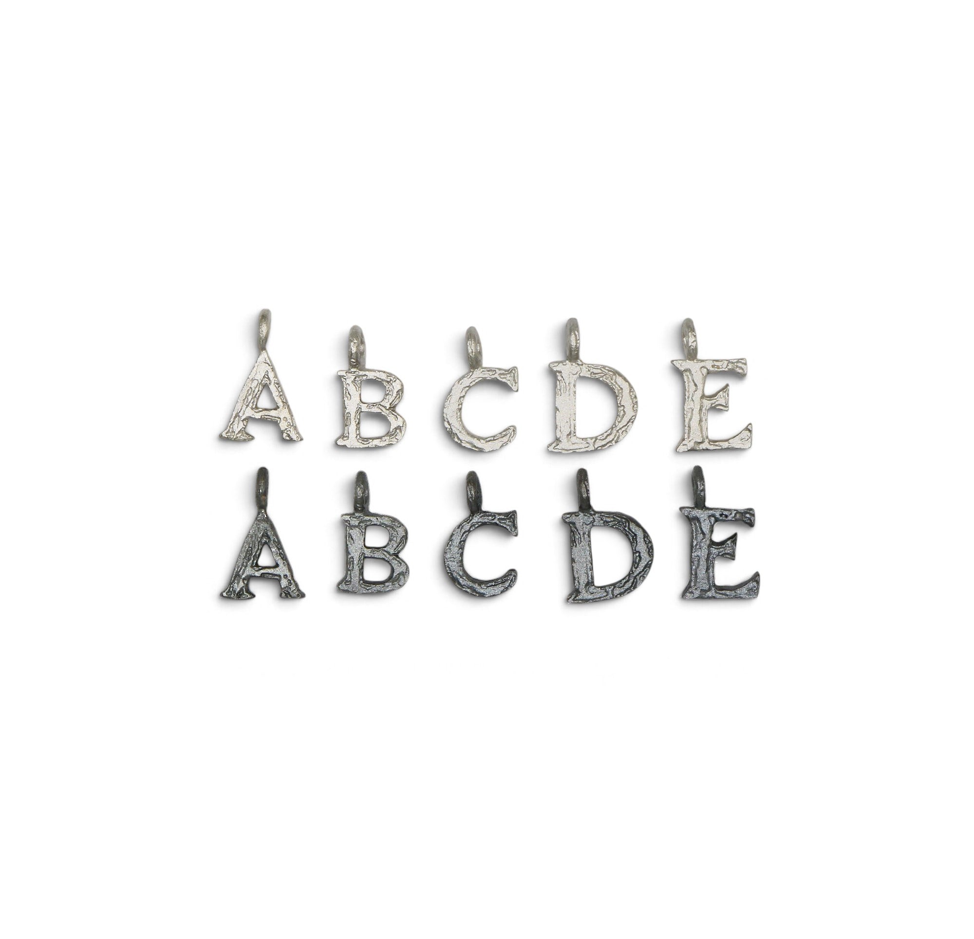 Five pairs of textured metal alphabet charms in the shape of letters A, B, C, D, and E, arranged in two rows on a plain white background.