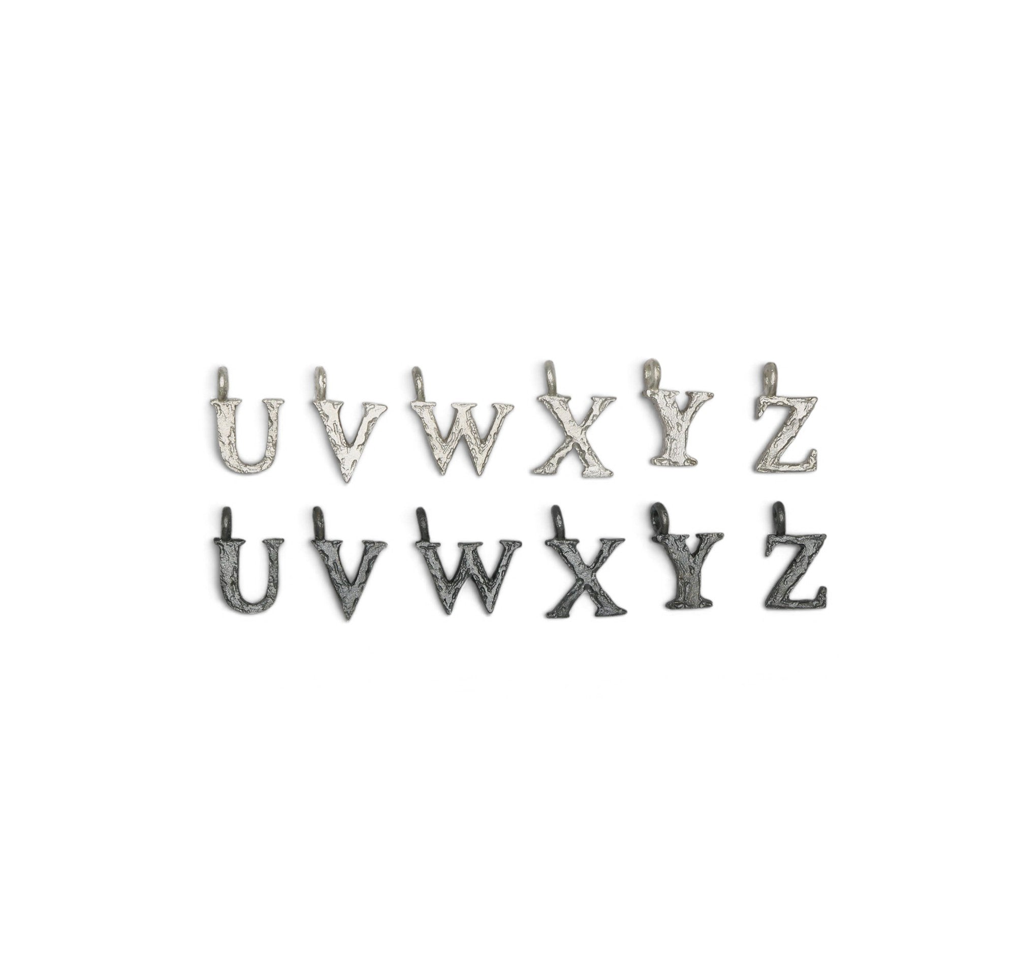 Textured Letter charms from U - Z on a white background 