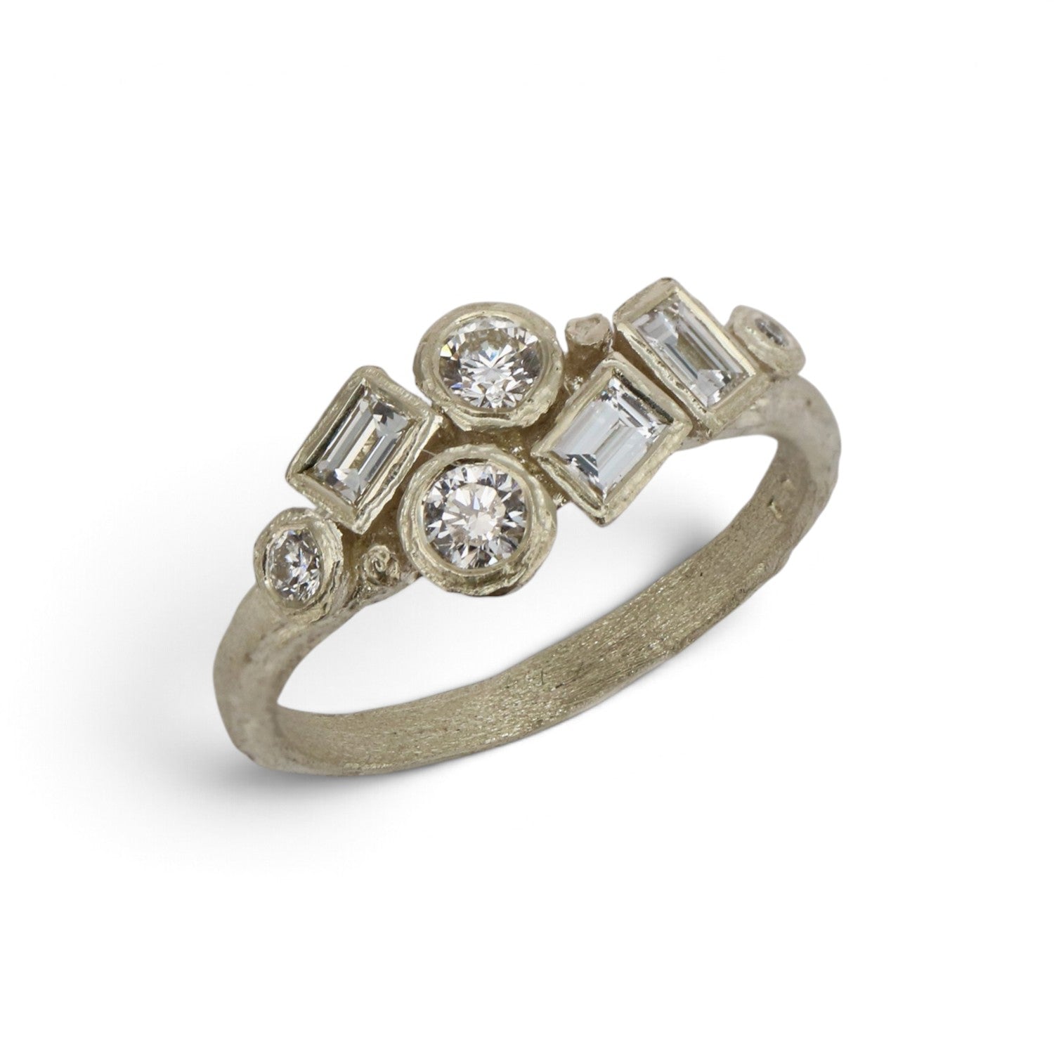 A textured silver ring featuring a cluster of clear baguette and round-cut gemstones, photographed on a clean white background.