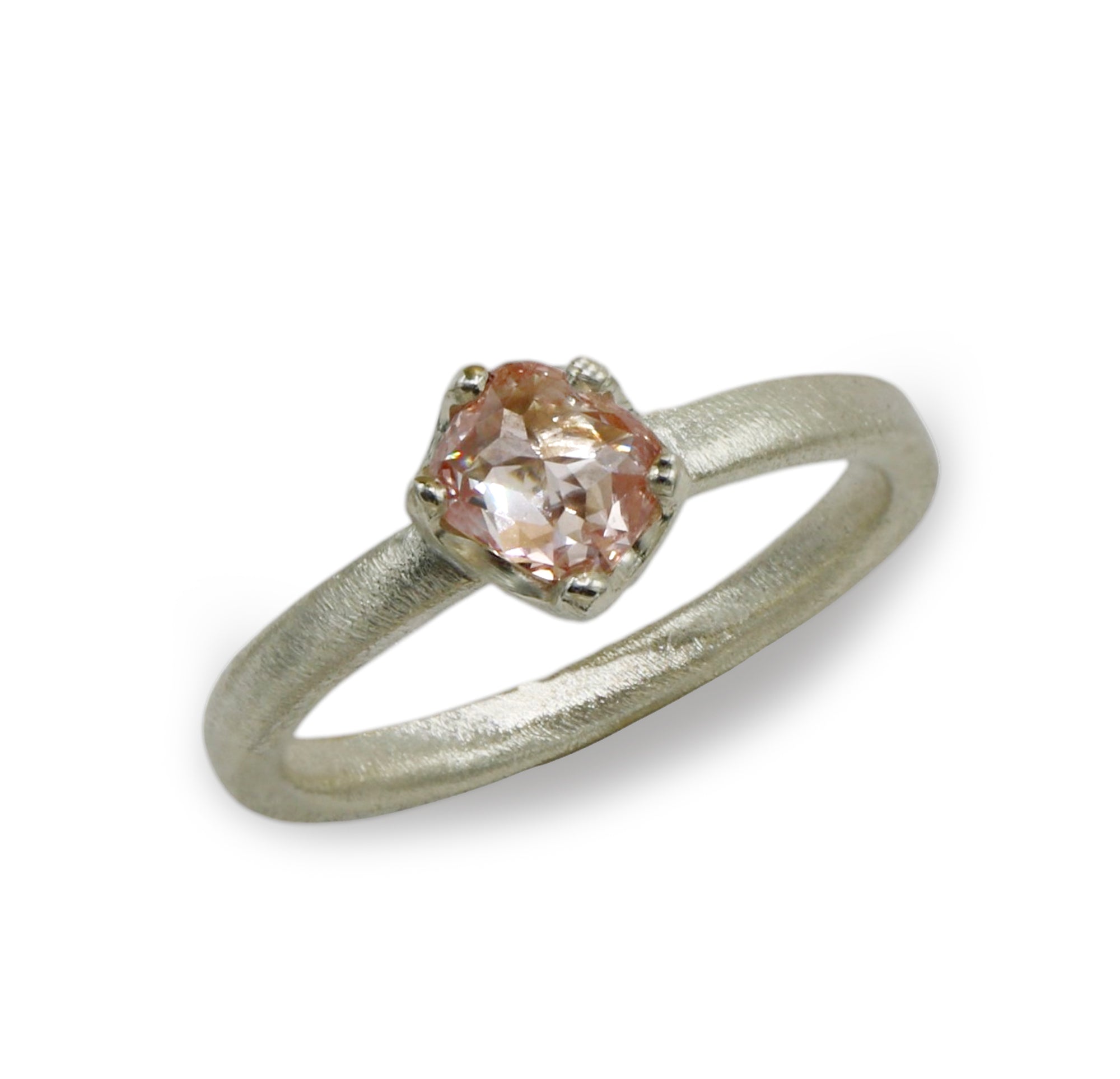 A 9ct white gold ring with a pink organic shaped diamond shown on a white background. 