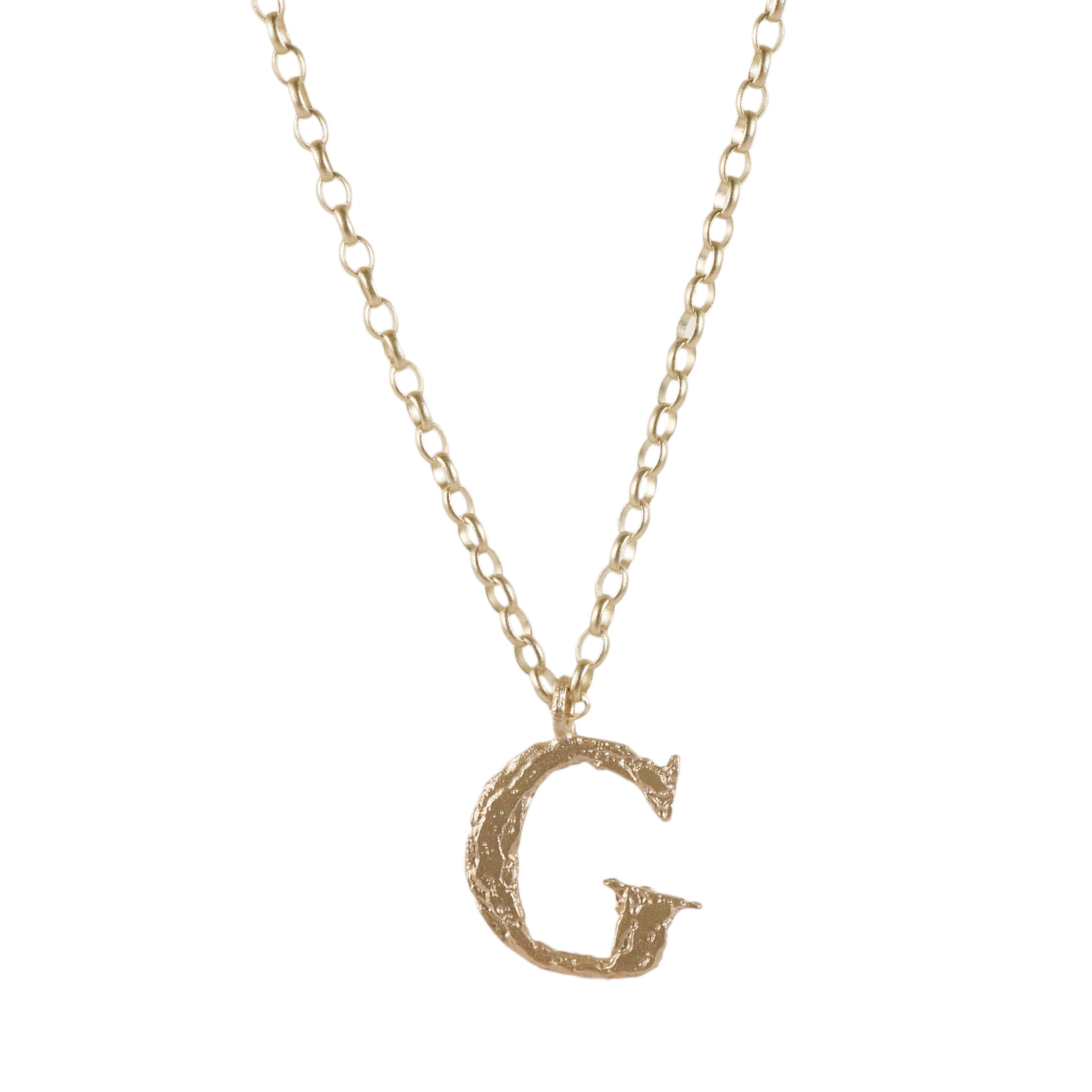 A gold initial necklace featuring a textured, hammered-style letter 'G' pendant on a delicate gold chain, shown against a plain white background.