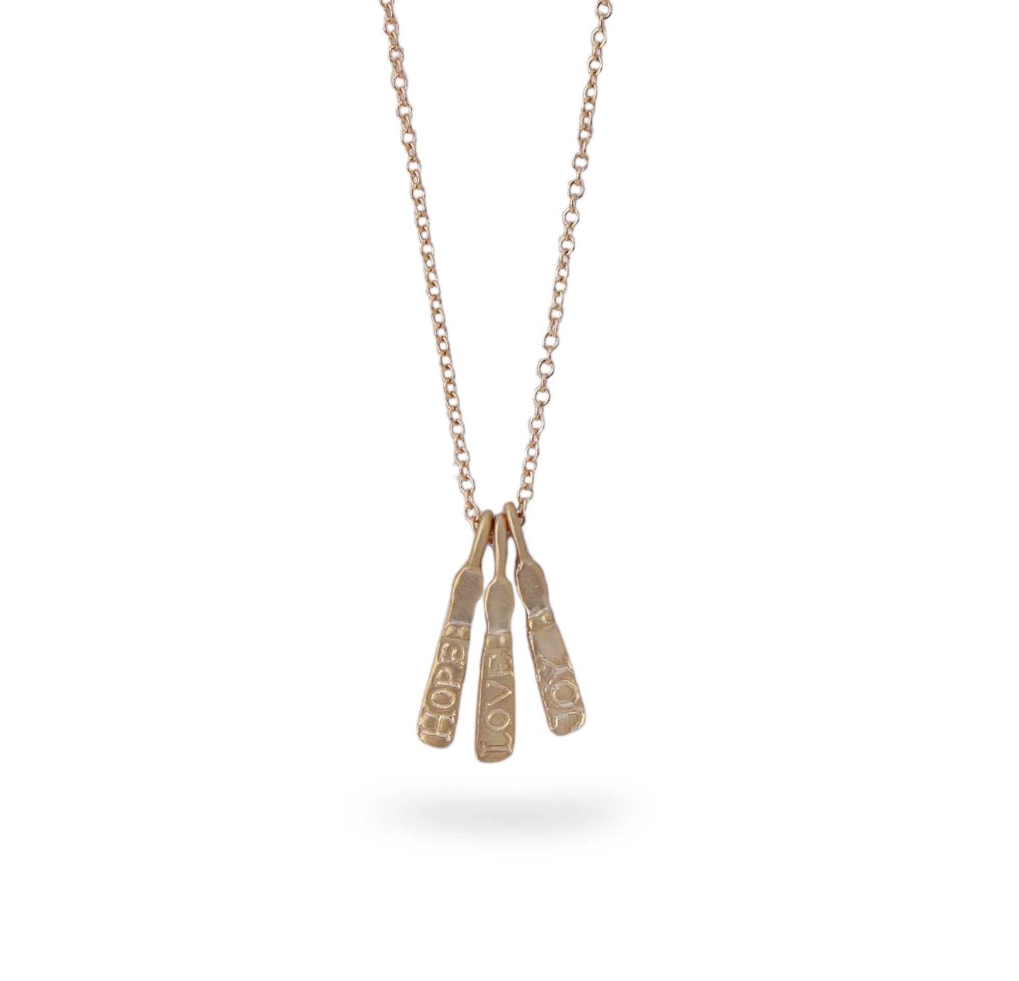 A gold necklace with three mini drop pendants etched with HOPE LOVE AND JOY in 9ct yellow gold. 