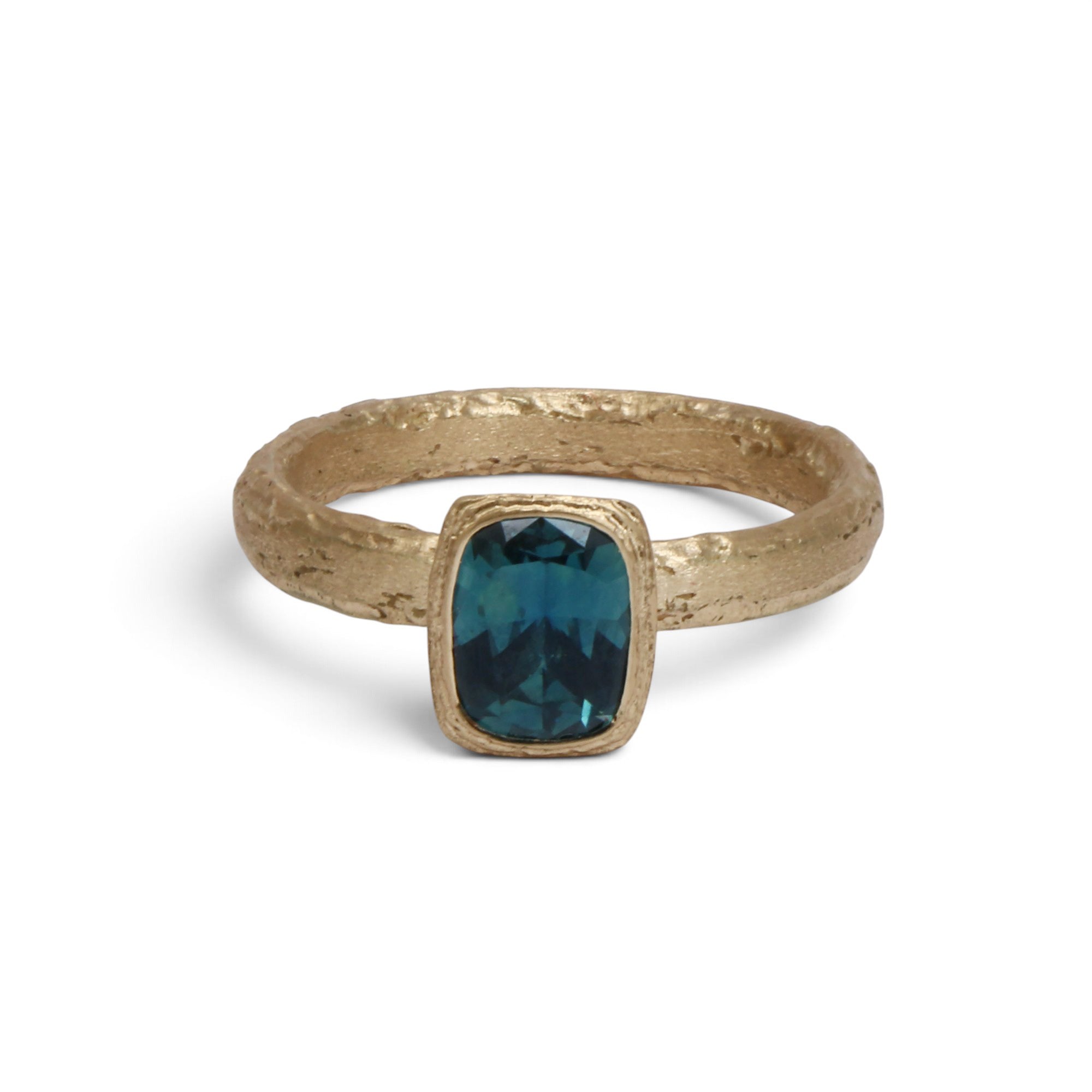 A textured gold ring featuring a rectangular cushion-cut dark teal gemstone, shown on a clean white background.