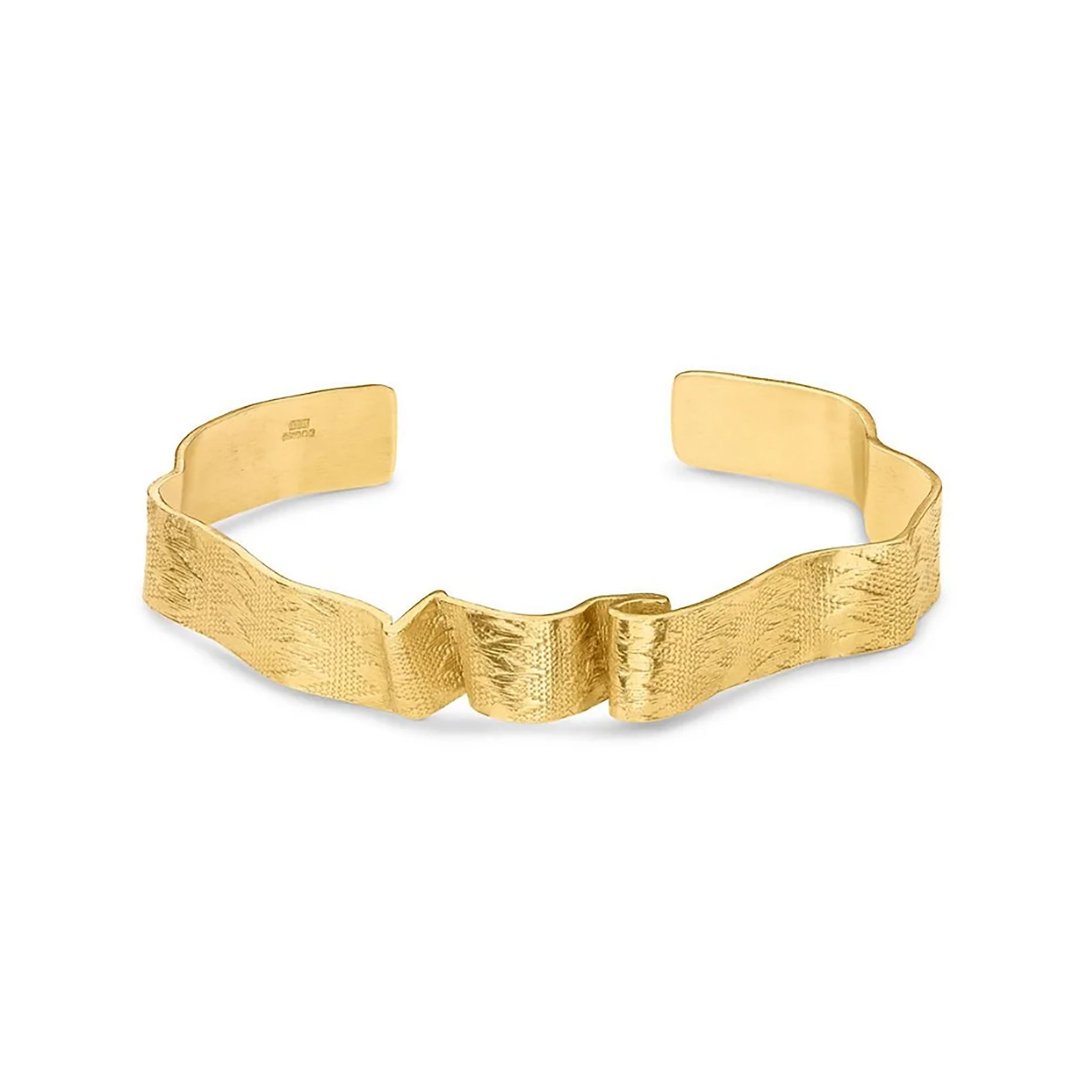 A textured gold cuff bracelet with a wavy, sculptural design and a central bow detail, photographed on a clean white background.