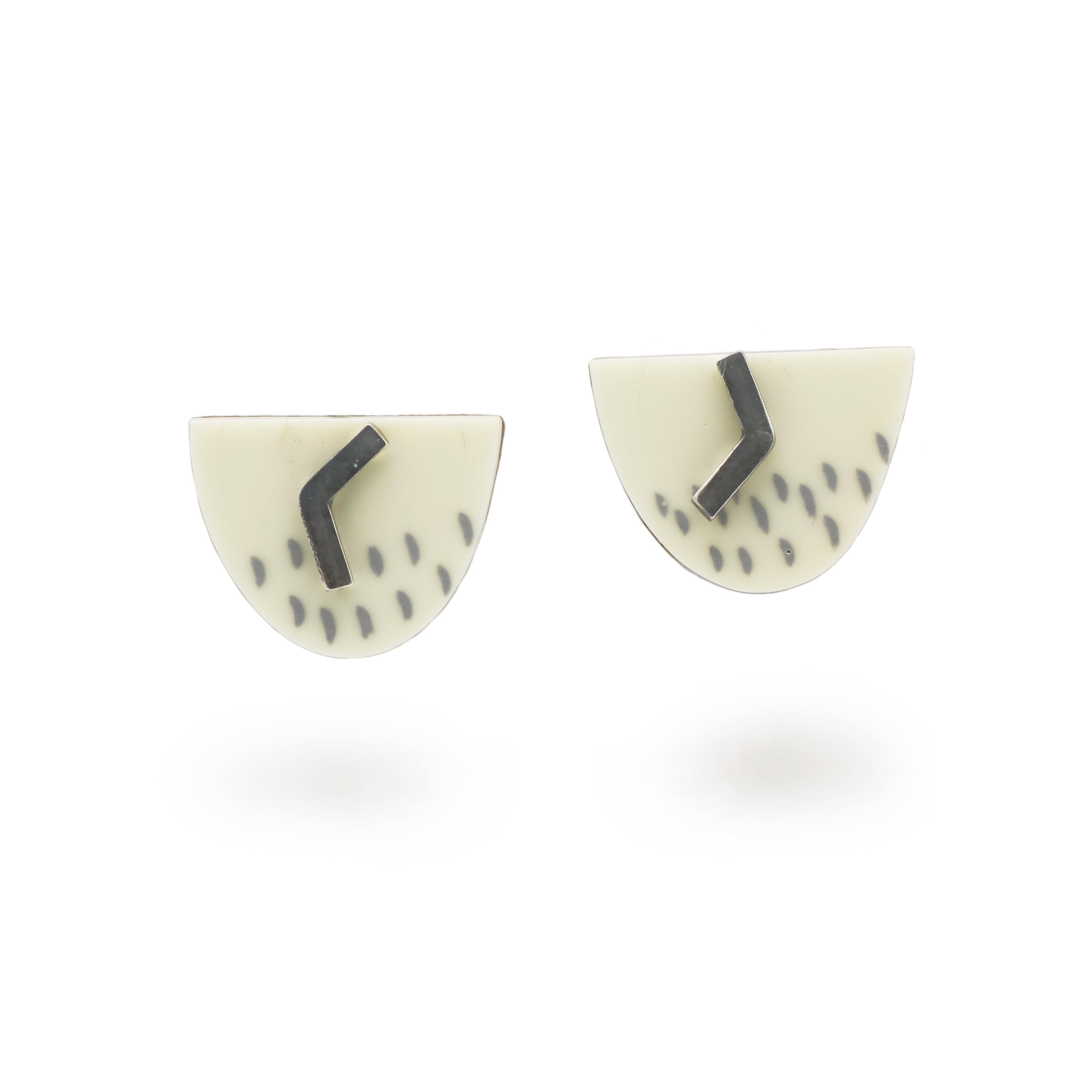 cream stud earrings with oxidised silver details on a white background
