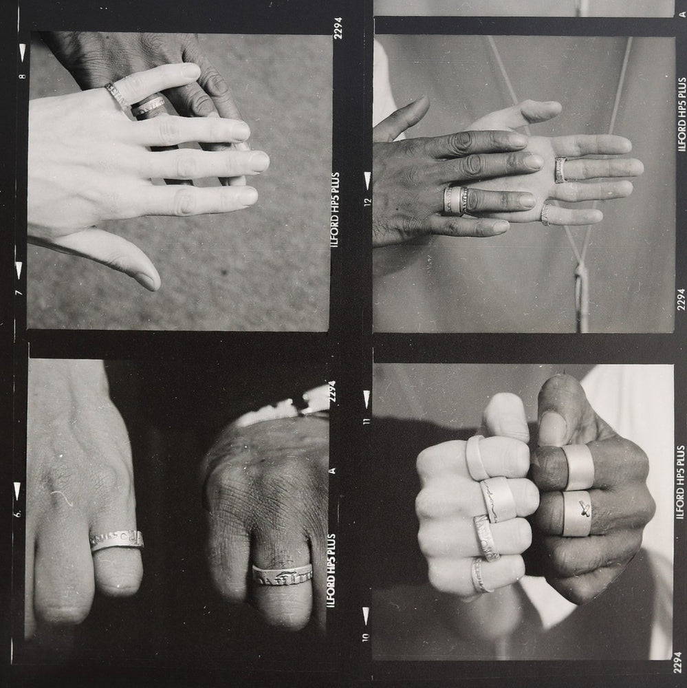 Black and white polaroid of hands wearing Diana Porter rings