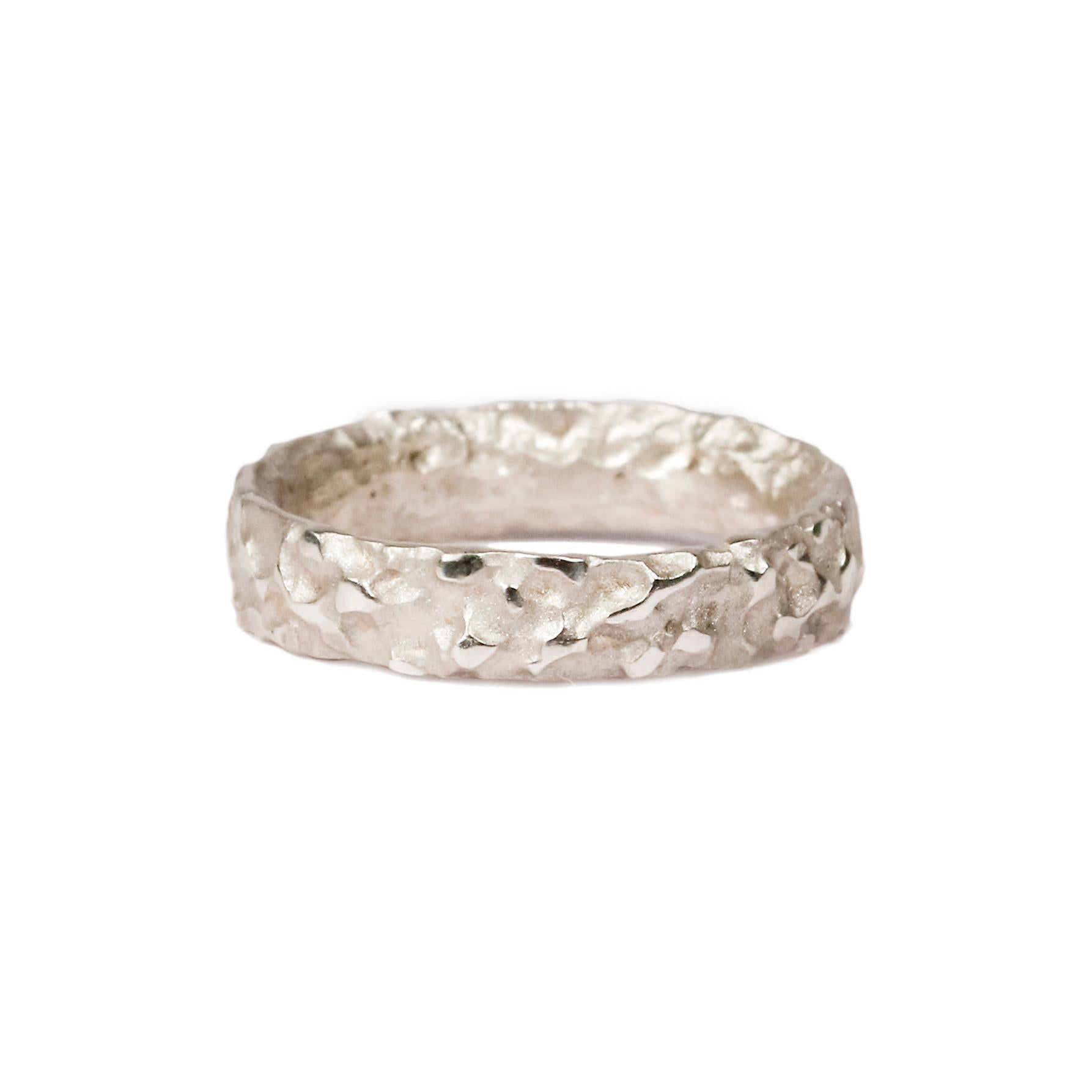 White gold wedding ring with molten texture on white background