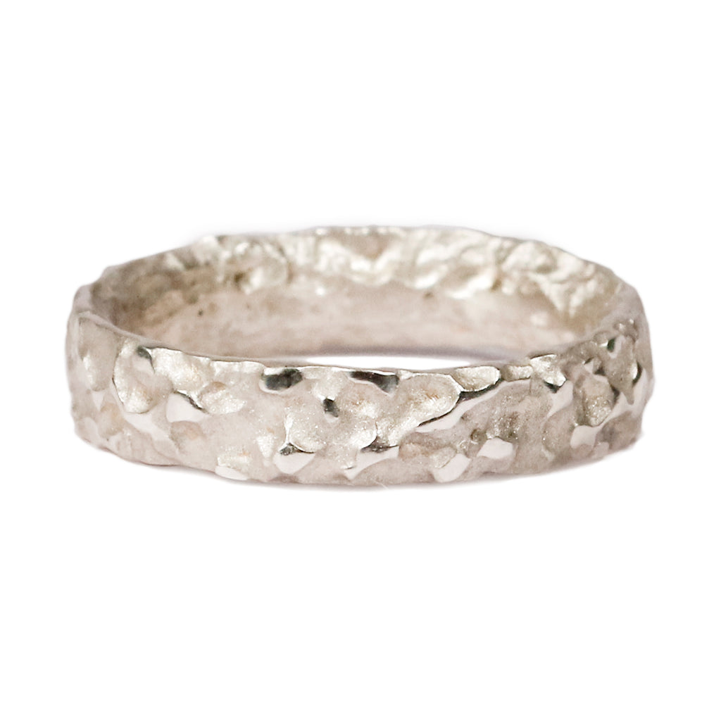 White gold wedding ring with molten texture on white background