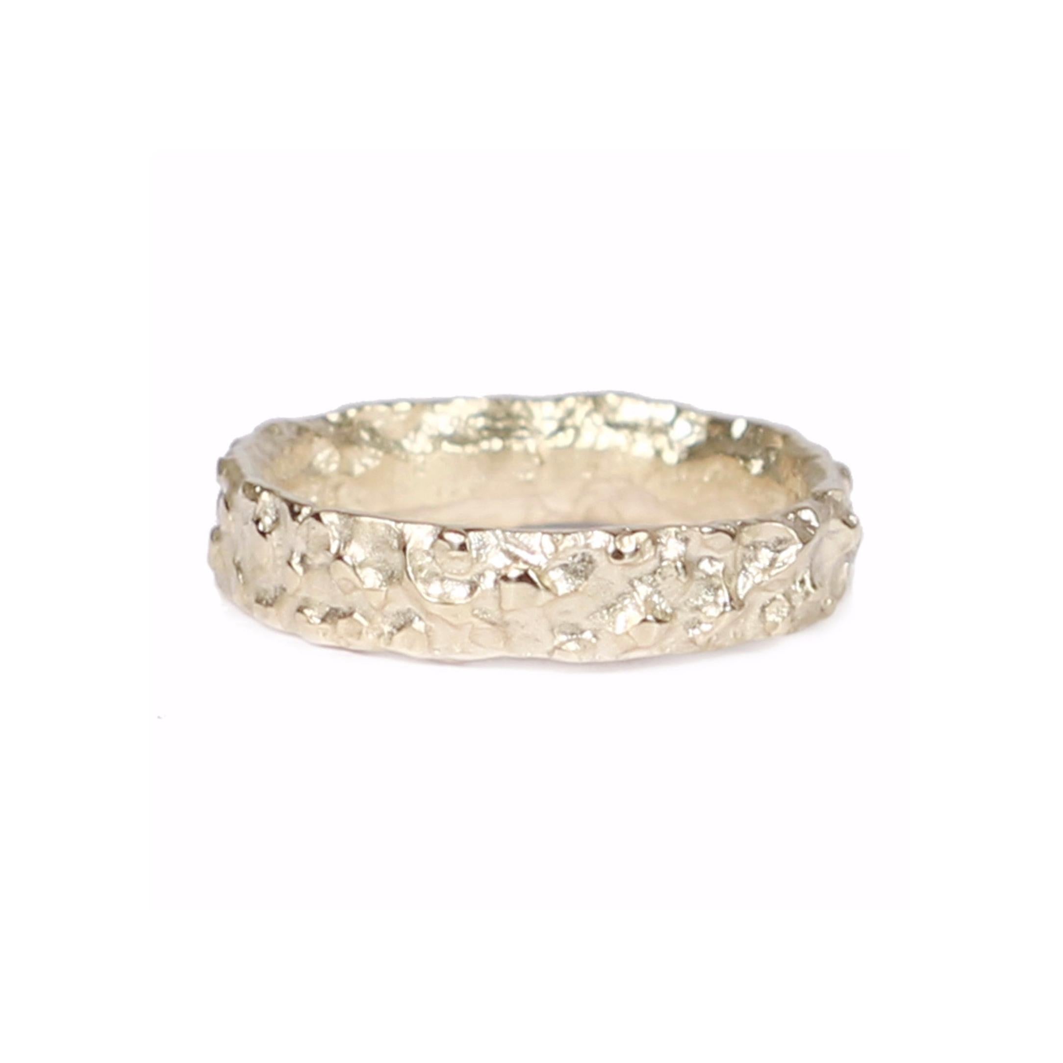 Yellow gold wedding ring with molten texture on white background