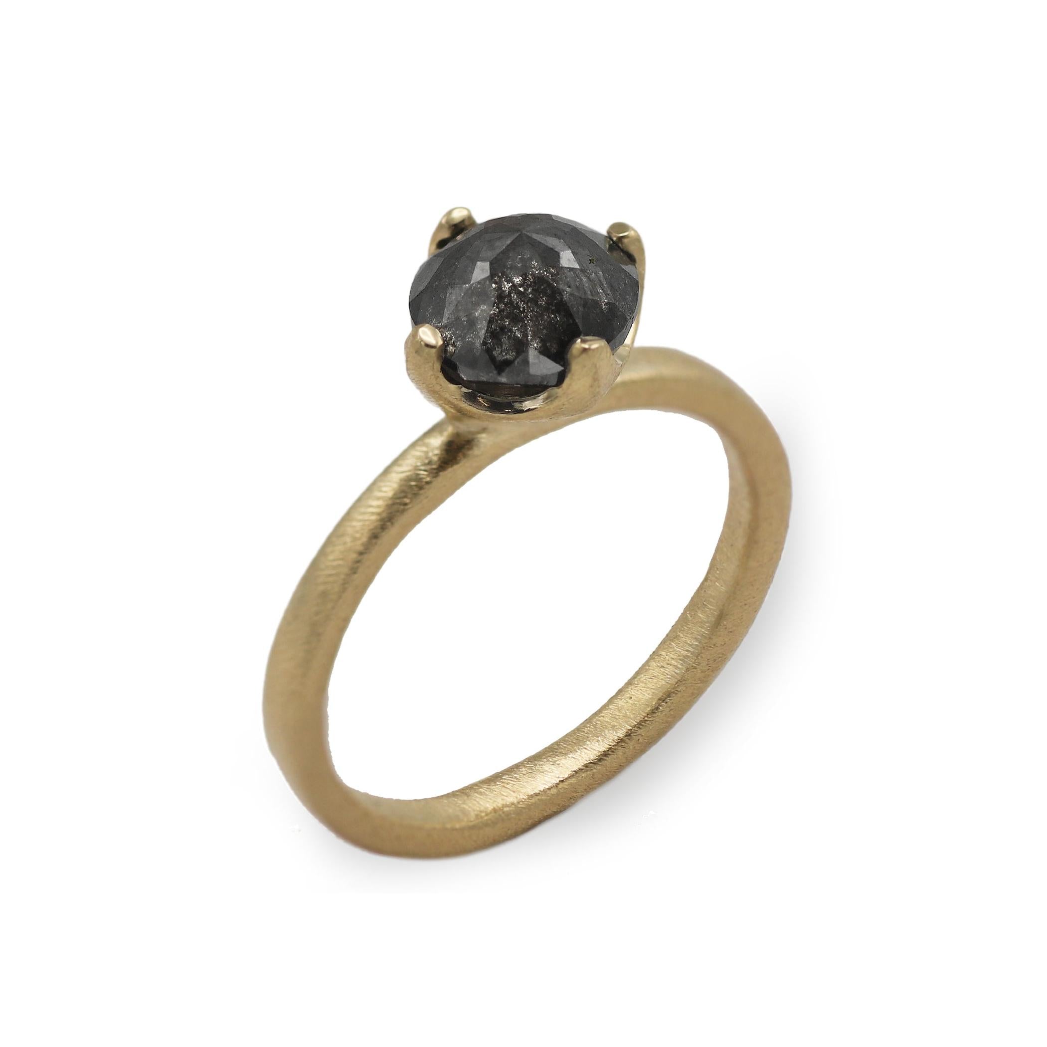 yellow gold engagement ring with black rose cut diamond on white background  