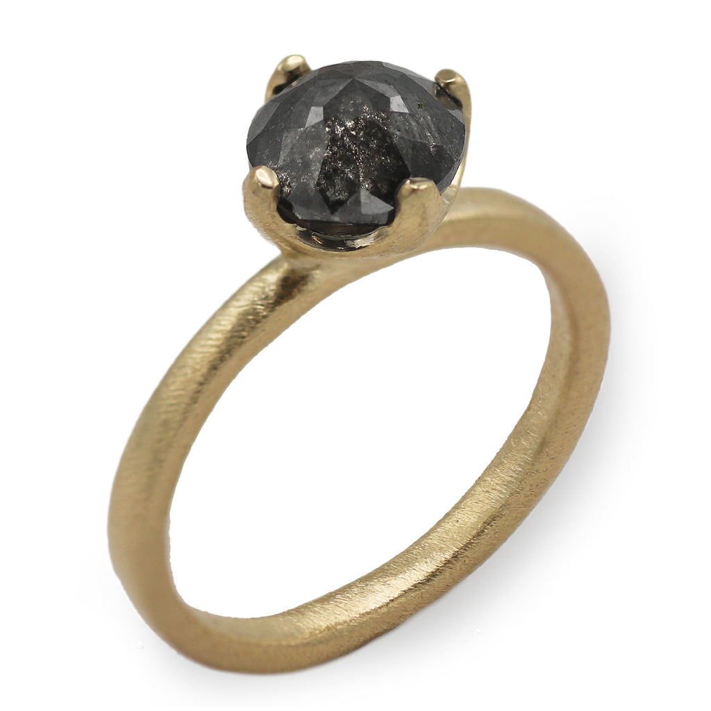 yellow gold engagement ring with black rose cut diamond on white background  