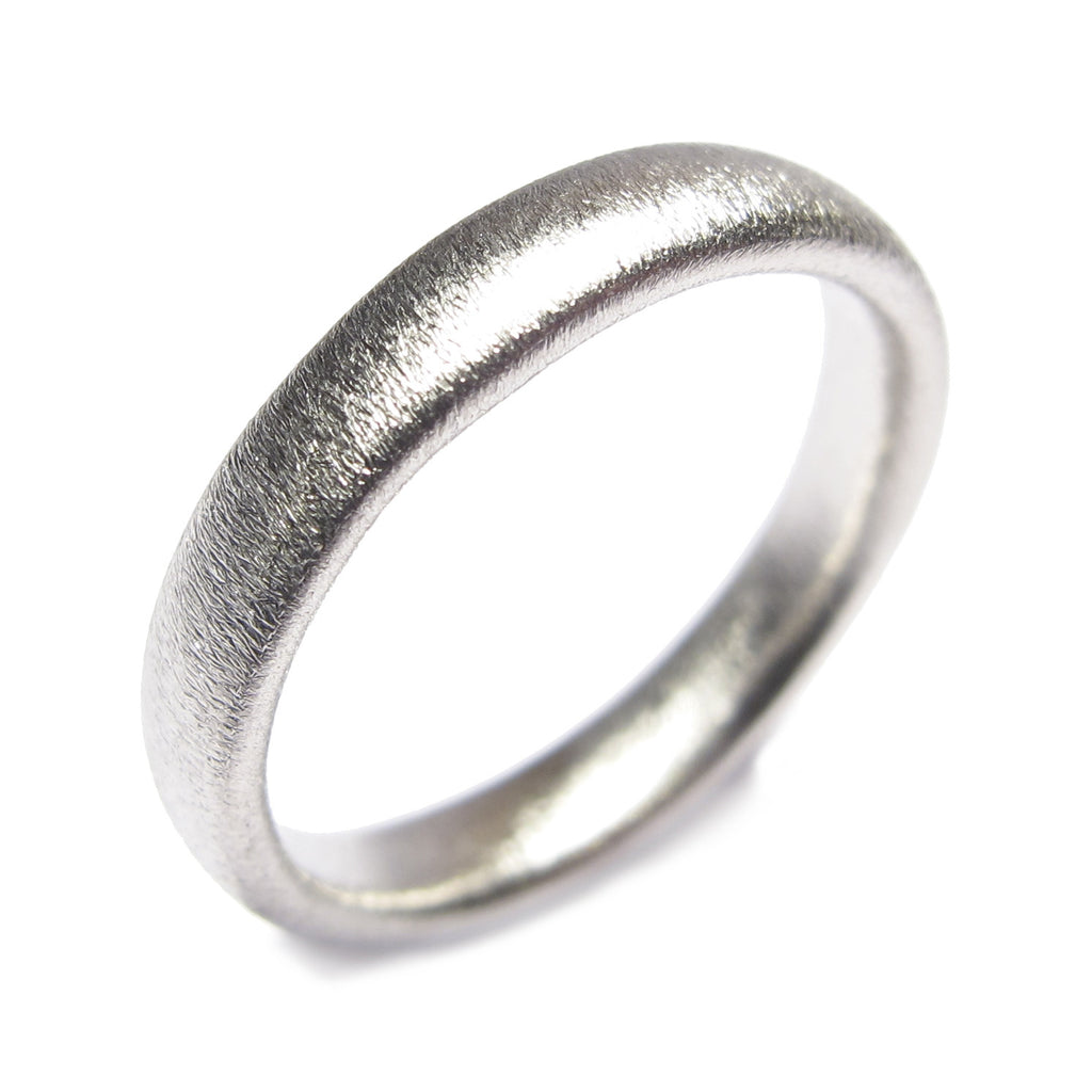 A narrow Platinum wedding ring with matt finish on white background