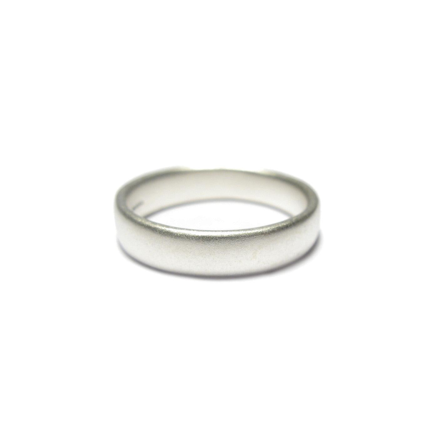 A plain silver wedding ring with a matt finish on a white background