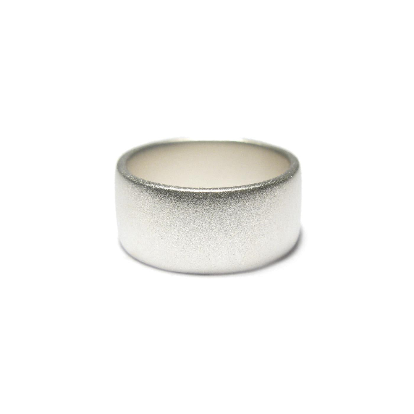 Wide silver ring with matt finish on a white background