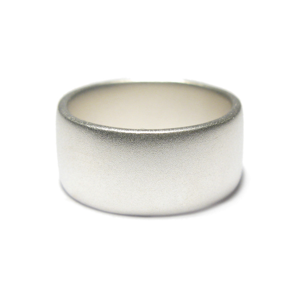 Wide silver ring with matt finish on a white background