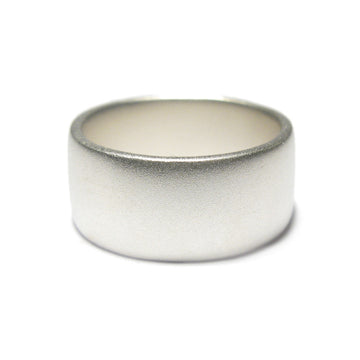 Wide silver ring with matt finish on a white background