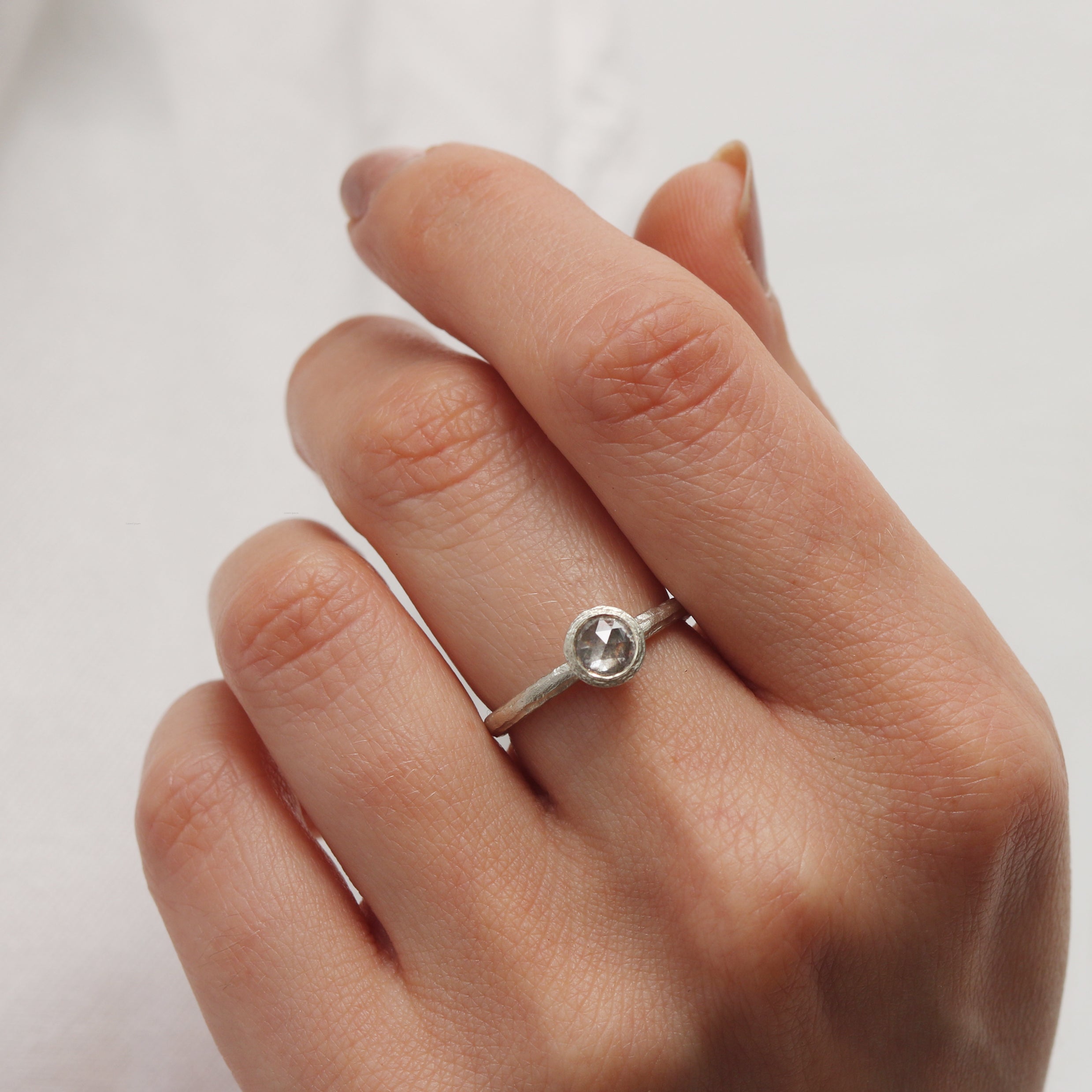 Textured White Gold set with a Grey Rose Cut Diamond worn on hand 